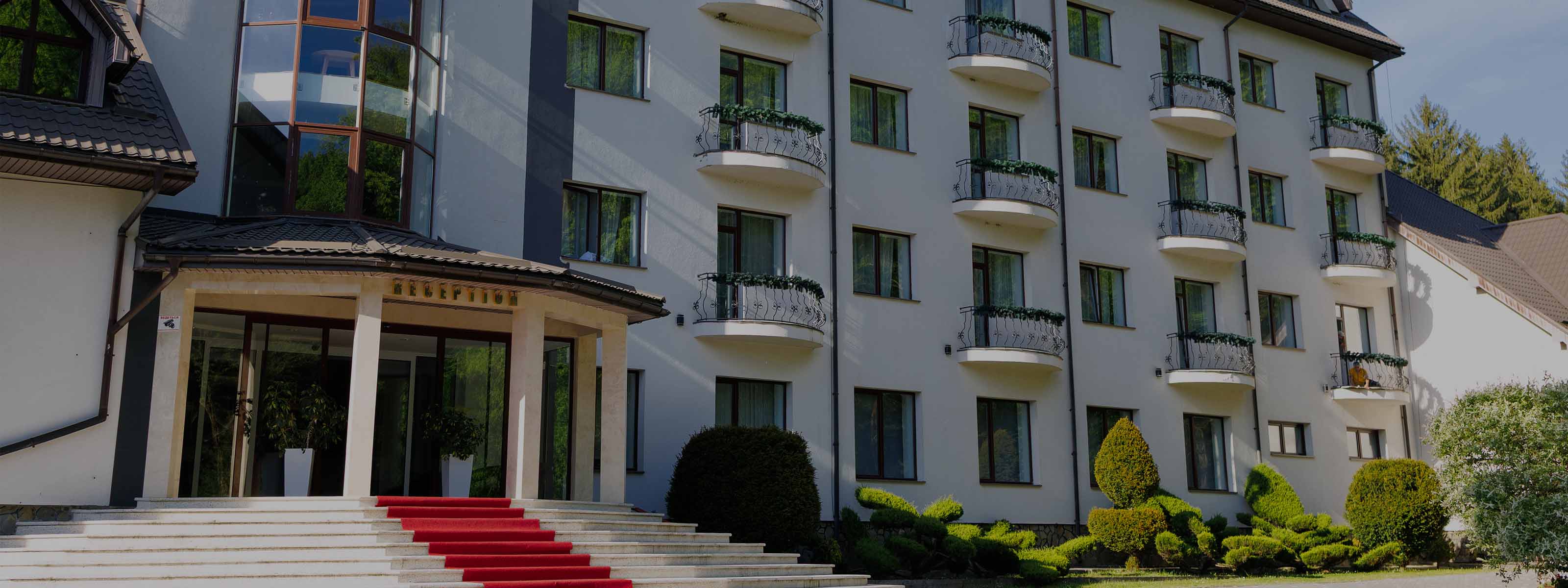 Центральний вхід Solotvyno Resort з червоною доріжкою, балконами та доглянутою територією