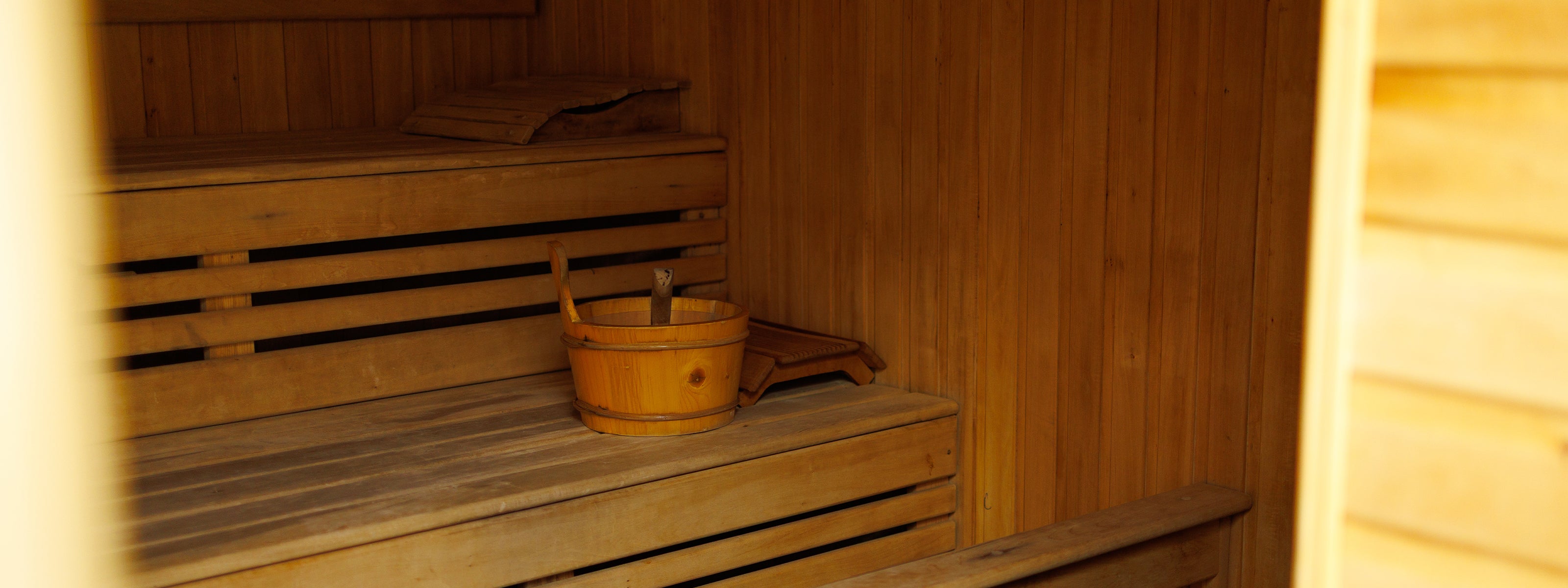 Дерев’яні полиці та відро для пари у традиційній фінській сауні Solotvyno Resort