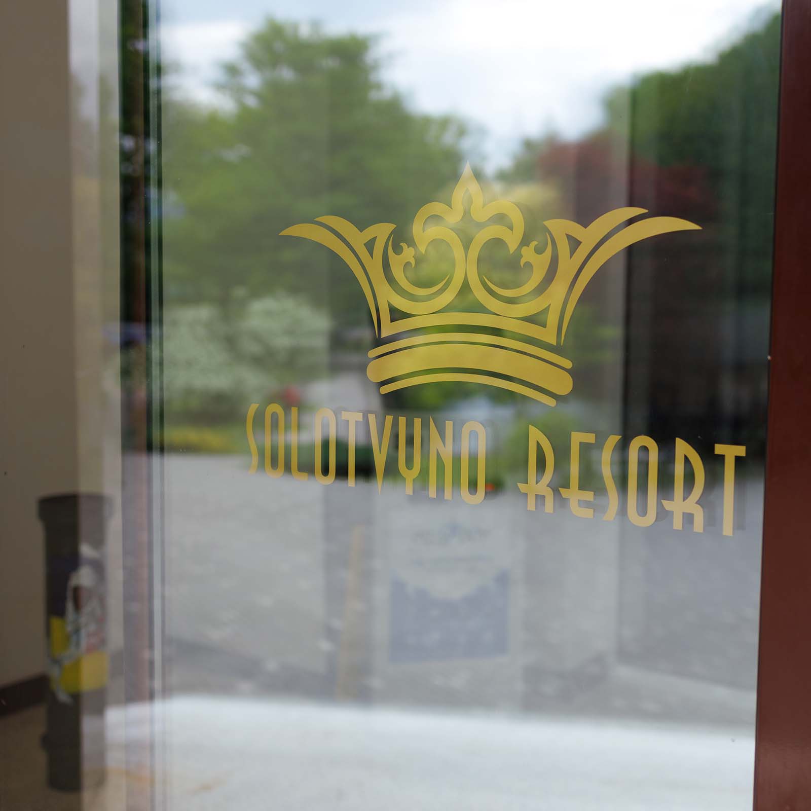 Логотип Solotvyno Resort на вхідних скляних дверях курорту