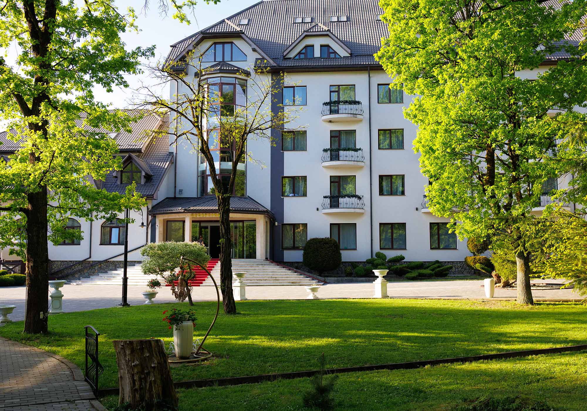 Готельний комплекс Solotvyno Resort — фасад будівлі з панорамними вікнами, балконами та зеленою територією